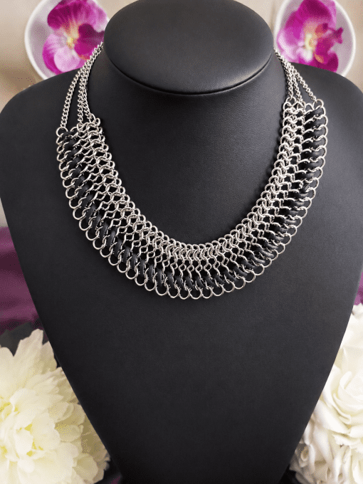 Collier plastron à mailles argentées et lanières noires