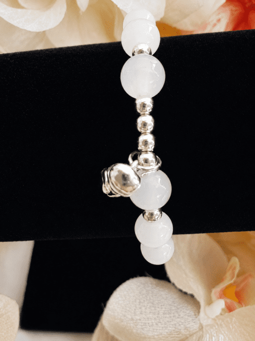 Bracelet élastique à perles blanches et détails argentés