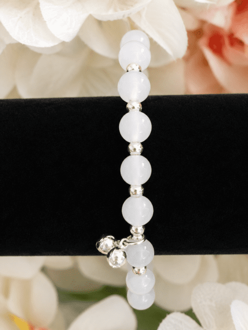 Bracelet élastique à perles blanches et détails argentés